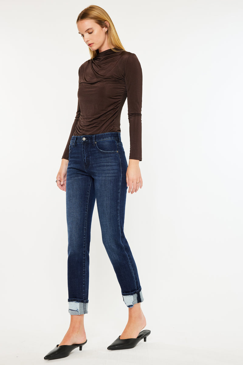 Model wearing mid rise skinny straight jeans with cuffed hem and dark wash