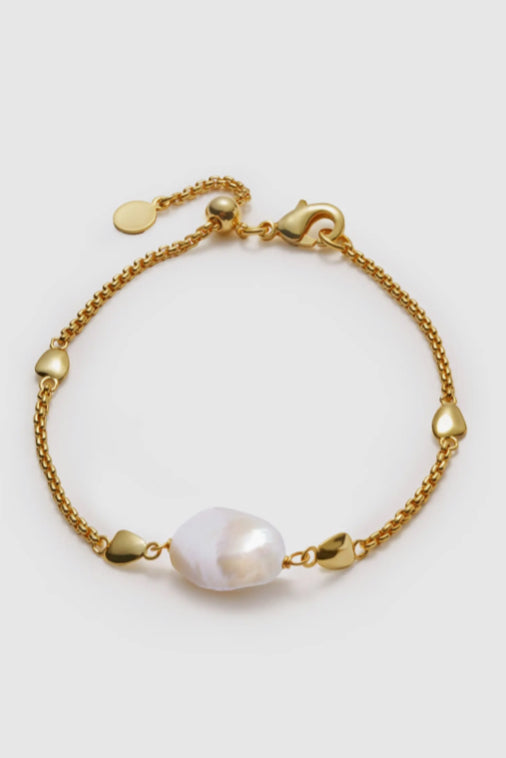 Gold chain bracelet with baroque pearl centerpiece, heart charms, and lobster clasp closure