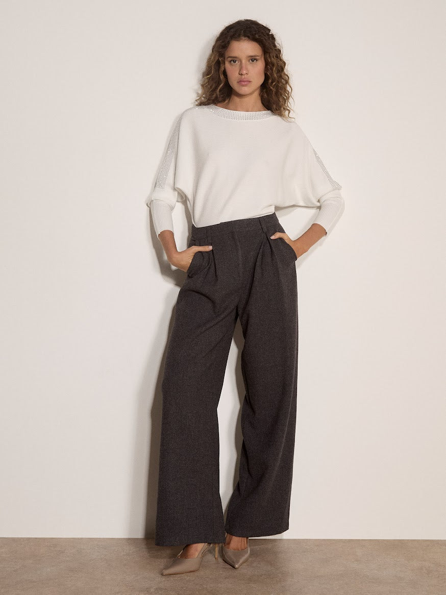 White ribbed jumper with diamante detail, worn with wide-leg dark grey trousers