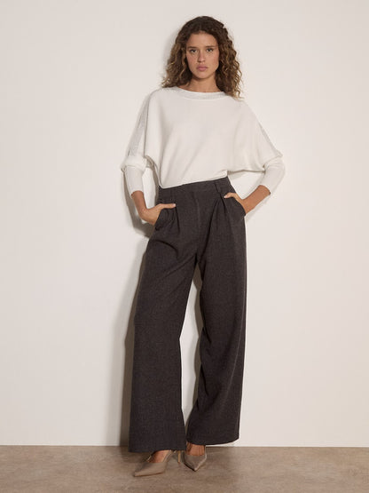 White ribbed jumper with diamante detail, worn with wide-leg dark grey trousers