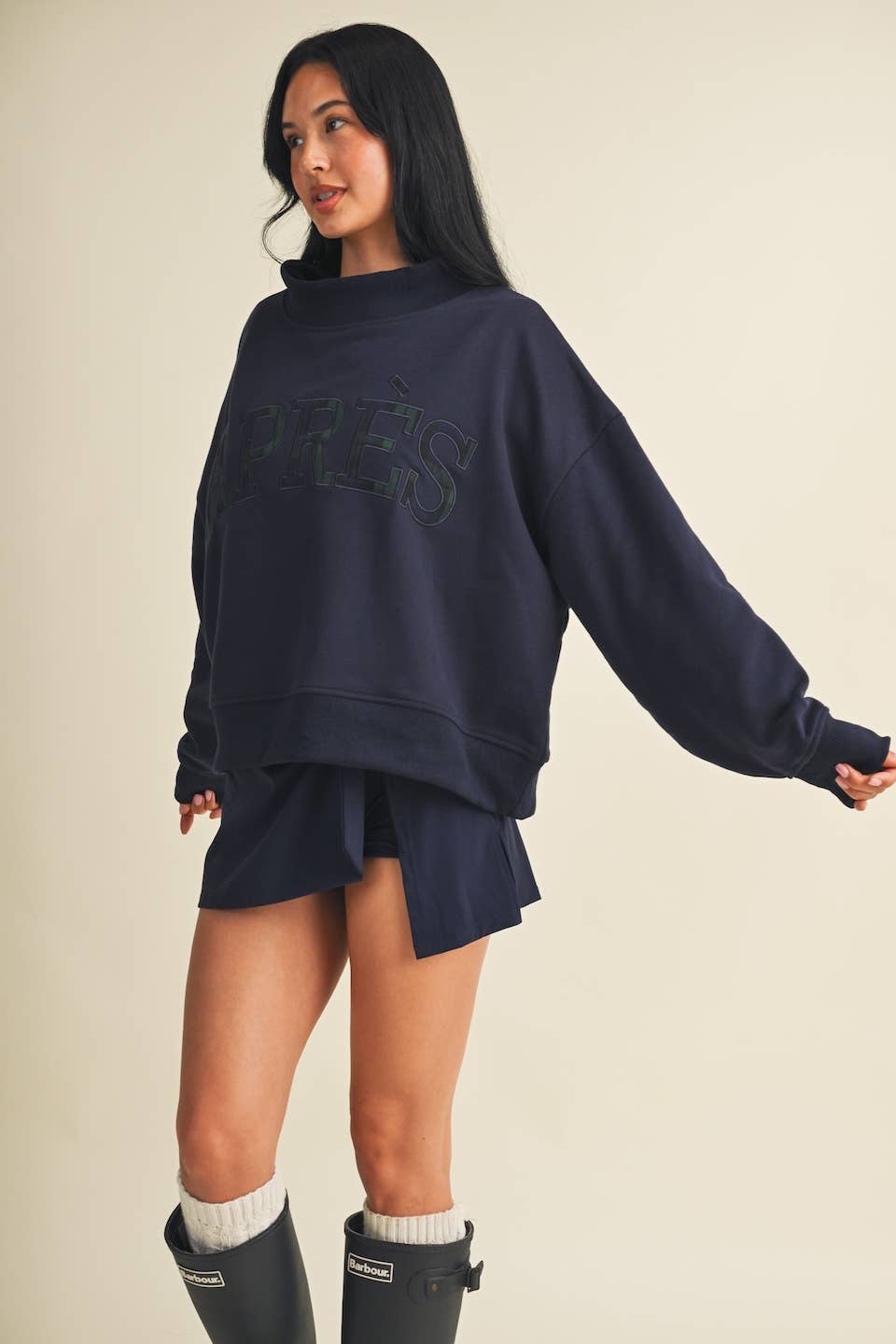 Model wearing oversized navy mock neck sweatshirt with tonal Après lettering and matching shorts
