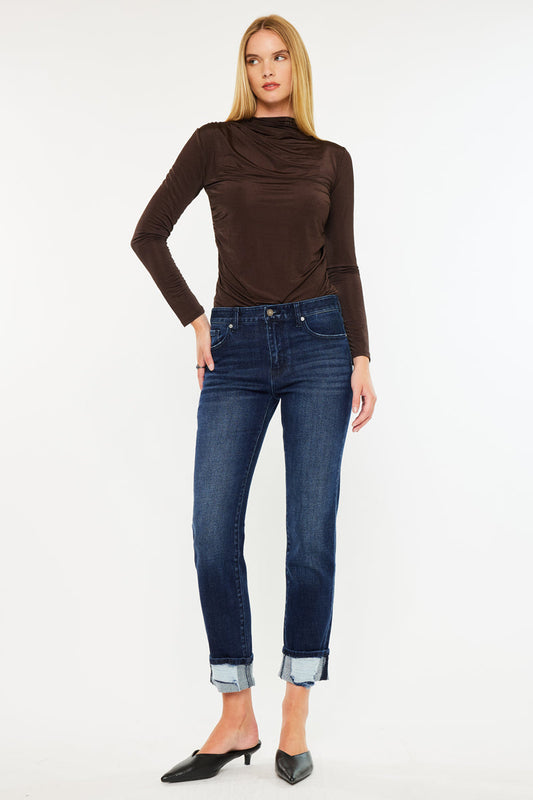 Model wearing KanCan mid rise skinny straight jeans with cuffed hem and brown top