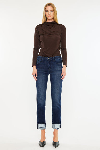 Model wearing mid rise skinny straight jeans with cuffed hem and brown long sleeve top