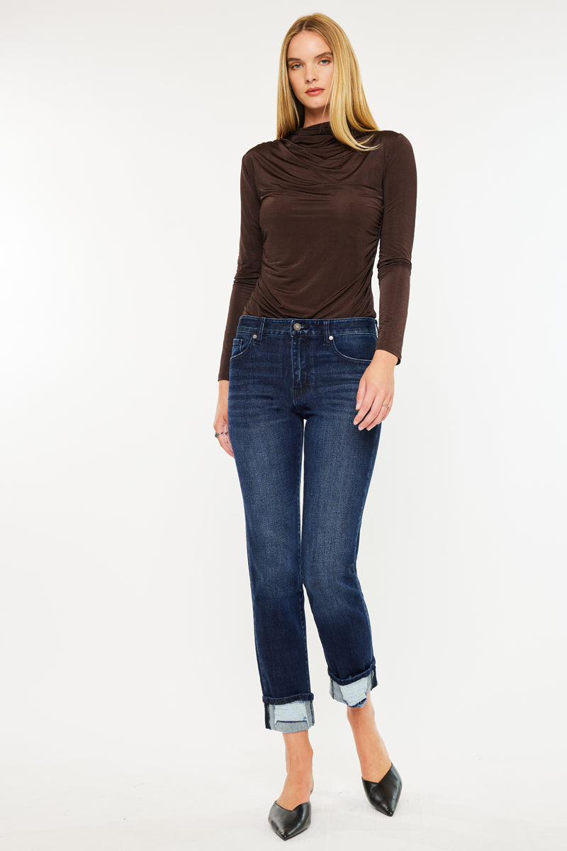 Model wearing mid rise skinny straight jeans with cuffed hem and dark wash denim