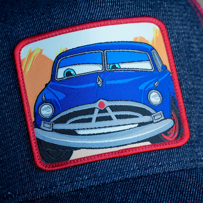 Close-up detail of Doc Hudson embroidered patch on denim Overlord x Pixar Cars cap