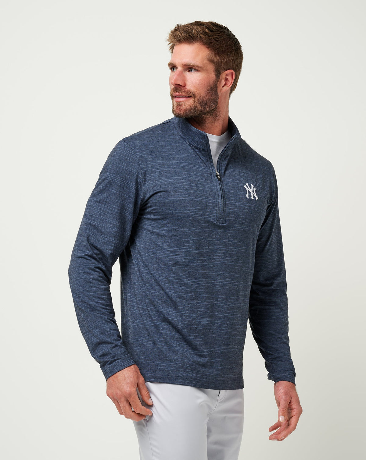 Man wearing Travis Mathew quarter-zip pullover with New York Yankees logo on chest